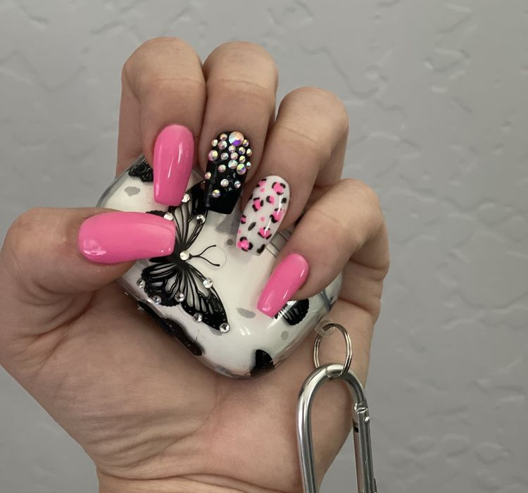 Close-up of a hand showcasing a vibrant pink nail design.